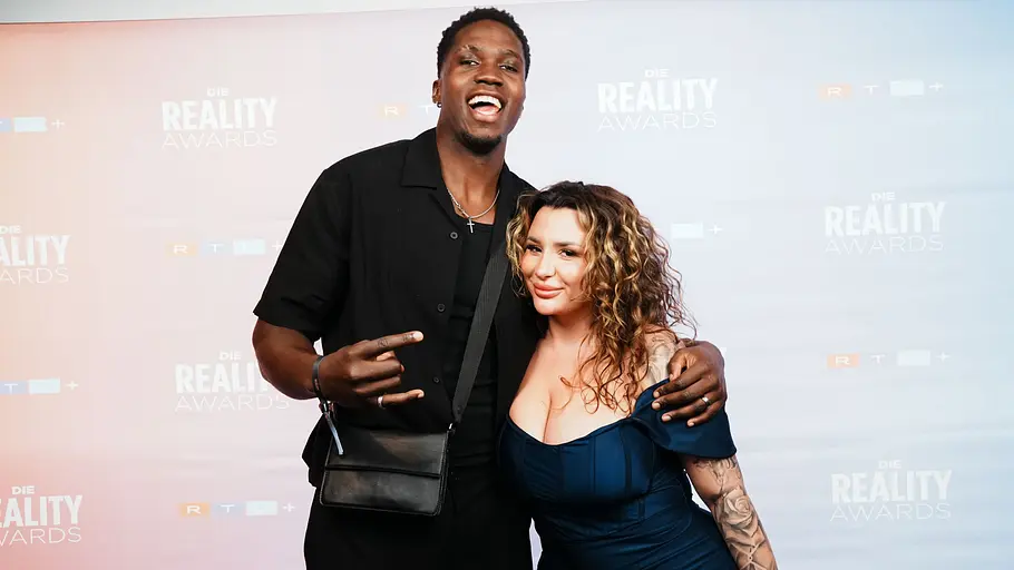 Joshi Josh und Sahel bei den Reality Awards Joshi Josh und Sahel posieren Arm in Arm vor der Fotowand der Reality Awards.