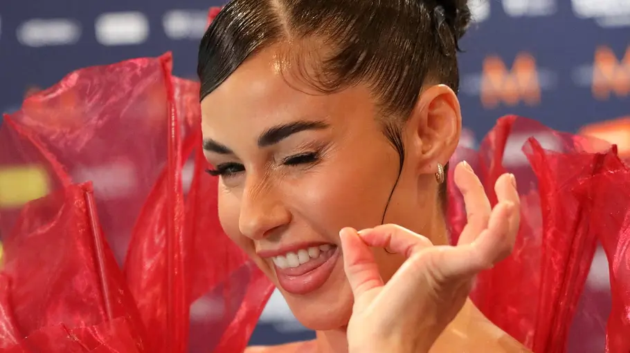 Gewinnt Sarah Engels den ESC 2026? Sarah Engels gibt sich beim ESC-Auftakt in Wien in einem roten Flammenkleid siegessicher und zwinkert in die Kamera.