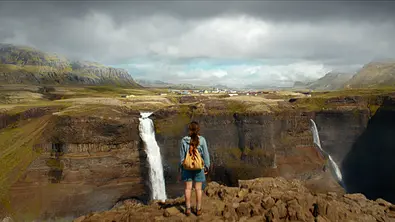 Elfi steht an einer Klippe und blickt auf mehrere Wasserfälle. - Foto: Netflix
