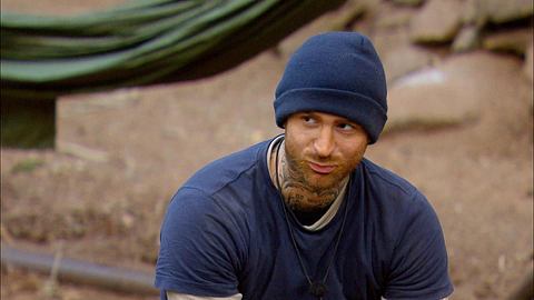 Gigi Birofio sitzt mit Mütze im Dschungelcamp - Foto: RTL