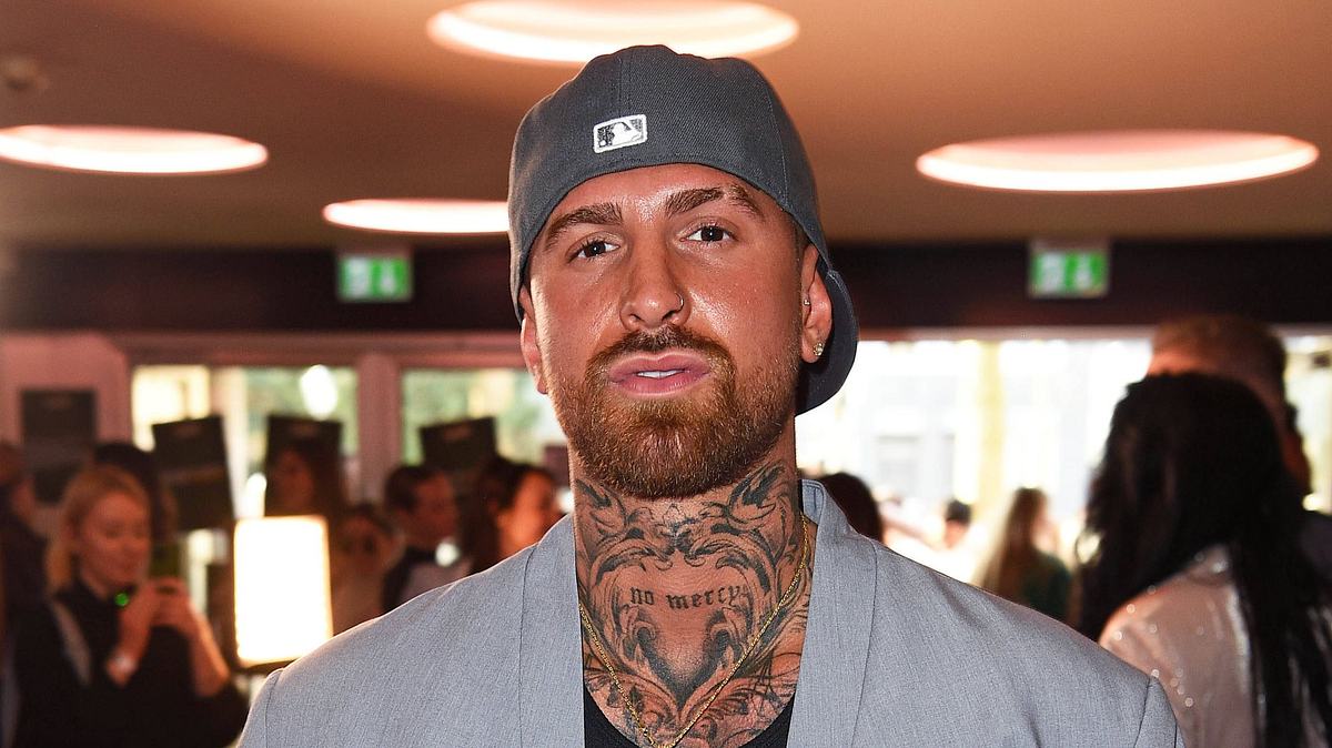 Gigi Birofio posiert mit umgedrehter Cap und grauem Blazer für die Kamera. Gigi Birofio posiert mit umgedrehter Cap und grauem Blazer für die Kamera.