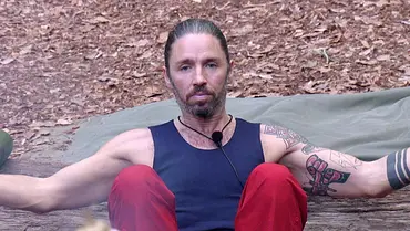 Gil Ofarim sitzt im Dschungelcamp auf dem Boden und hebt fassungslos und fragend die Arme in die Höhe.  - Foto: RTL