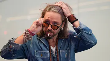 Gil Ofarim fährt sich mit einer Hand durchs Haar und setzt sich mit der anderen Hand eine Sonnenbrille auf. - Foto: IMAGO / BOBO
