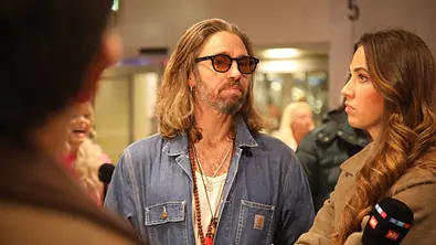 Gil Ofarim mit ernstem Blick und Brille am Flughafen. - Foto:  IMAGO / Matthias Wehnert