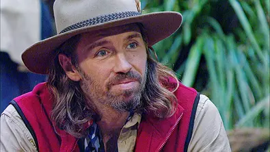 Gil Ofarim im Dschungelcamp 2026 mit Hut blickt er halb lächelnd rechts aus dem Bild - Foto: RTL
