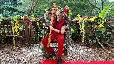 Gil Ofarim sitzt auf einem Thron und küsst das Dschungelcamp-Zepter.  - Foto: RTL