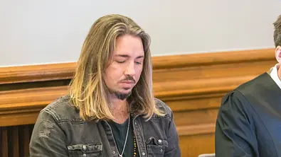 Gil Ofarim sitzt vor Gericht und schaut auf den Boden. - Foto: IMAGO / Christian Grube