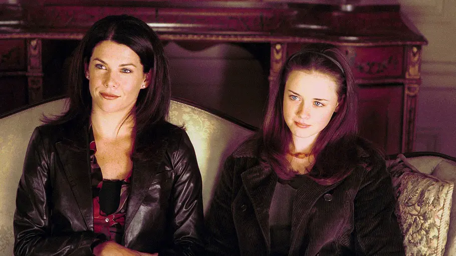 Gilmore Girls Die Gilmore Girls Lorelai und Rory sitzen im Jahr 2000 in der Serie auf einem Sofa.