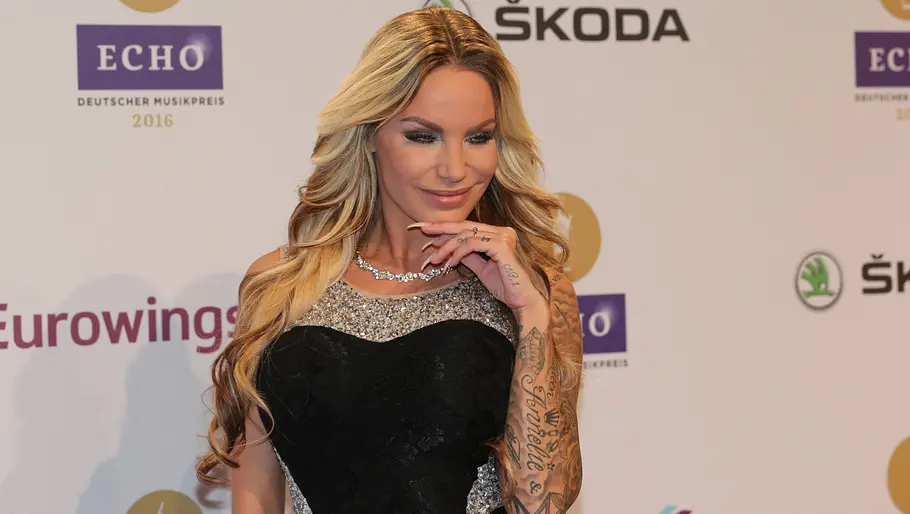 Gina-Lisa Lohfink 2016 Gina-Lisa in schwarzem Abendkleid mit Schmuck posiert vor einer Sponsorenwand.