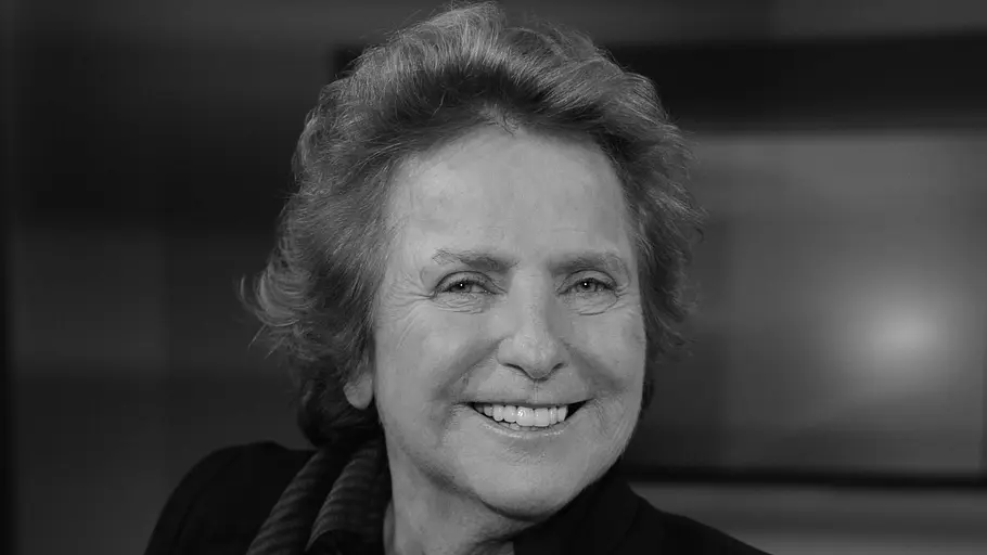 Gisela Marx' Rolle in der deutschen Fernsehlandschaft bleibt unvergessen. Gisela Marx lächelt auf einer Schwarz-Weiß-Aufnahme. Sie trägt eine dunkle Jacke und einen gestreiften Schal.