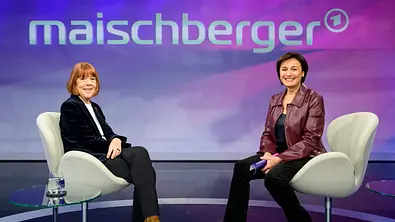 Zwei Frauen sitzen sich in einem Fernsehstudio gegenüber und lächeln in die Kamera, im Hintergrund ist das Logo „maischberger“ zu sehen. - Foto: IMAGO / HMB-Media