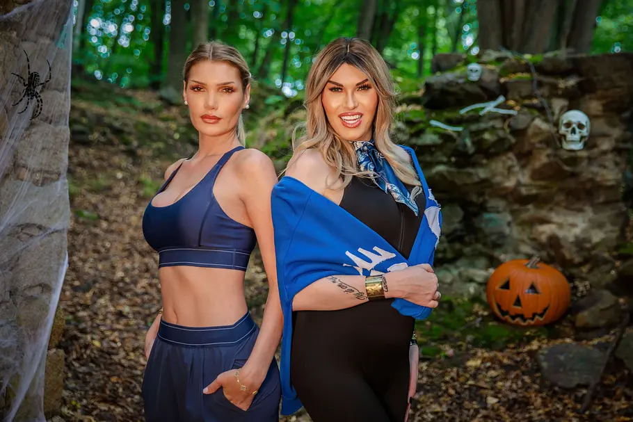 Giuliana Farfalla & Valencia Stöhr Giuliana Farfalla & Valencia Stöhr posieren im Wald vor Halloween-Deko mit Kürbis, Totenköpfen und Spinnweben.