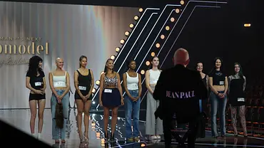 Mehrere weibliche Kandidatinnen stehen in unterschiedlichen Outfits aufgereiht auf dem Catwalk bei „Germanys Next Topmodel“. Im Hintergrund ist die Studiobeleuchtung zu sehen, während die Frauen gespannt auf das Casting warten. - Foto: Seven.One Entertainment Group GmbH