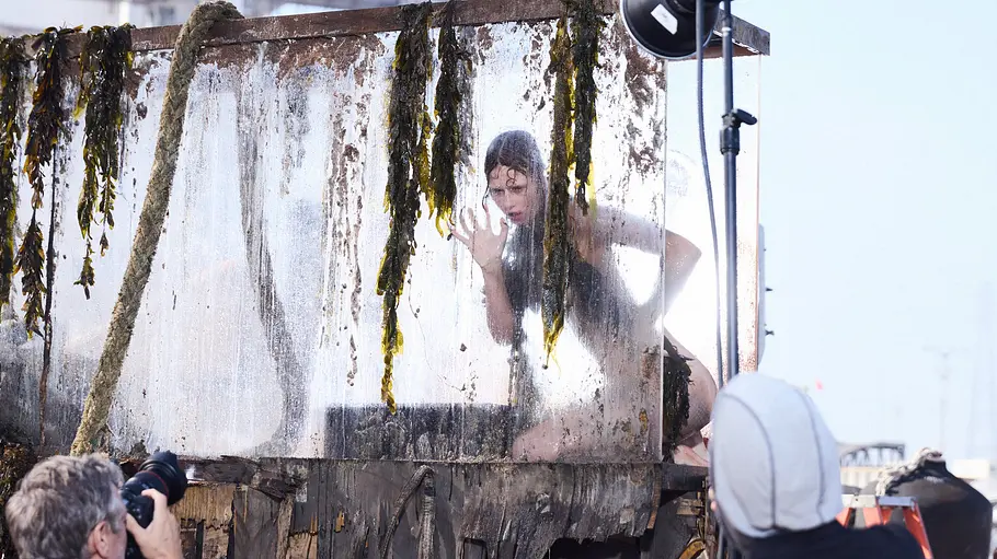 Ein Model bei GNTM posiert im Glastank als „High-Fashion-Fisch“ fürs Nacktshooting mit Rankin.