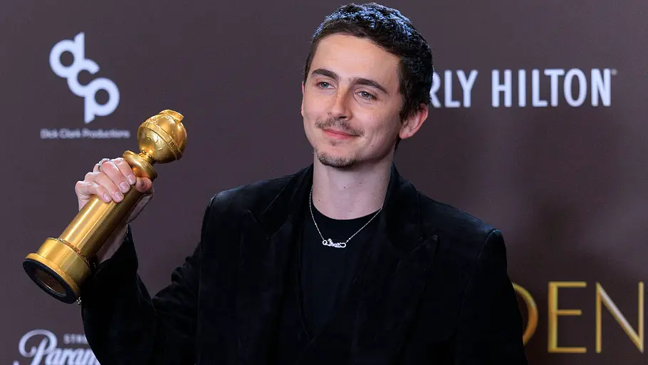 Golden Globes 2026 Timothee Chalamet steht mit einem Golden Globe vor der Fotowand der Golden Globes.