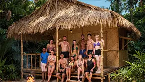 Die Teilnehmer:innen der Realityshow „Good Luck Guys“ posieren gemeinsam vor einer strohgedeckten Dschungelhütte. Die Gruppe trägt überwiegend Badebekleidung und Sommerkleidung, einige sitzen auf den Stufen der Hütte, andere stehen auf der Veranda. Im Vordergrund brennt ein Lagerfeuer, während dichter tropischer Wald die Kulisse umgibt. - Foto: Joyn Die Teilnehmer:innen der Realityshow „Good Luck Guys“ posieren gemeinsam vor einer strohgedeckten Dschungelhütte. Die Gruppe trägt überwiegend Badebekleidung und Sommerkleidung, einige sitzen auf den Stufen der Hütte, andere stehen auf der Veranda. Im Vordergrund brennt ein Lagerfeuer, während dichter tropischer Wald die Kulisse umgibt. - Foto: Joyn