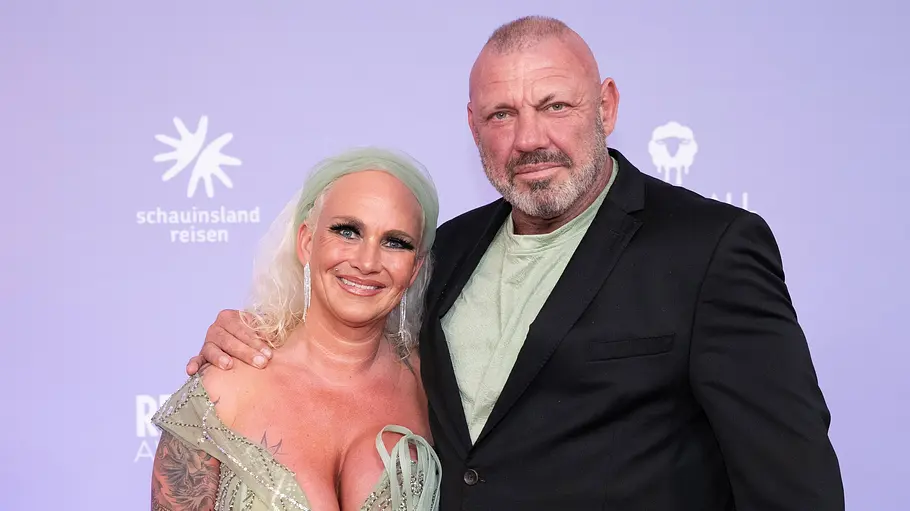Caro und Andreas Robens stehen vor einer Fotowand der Reality Awards.