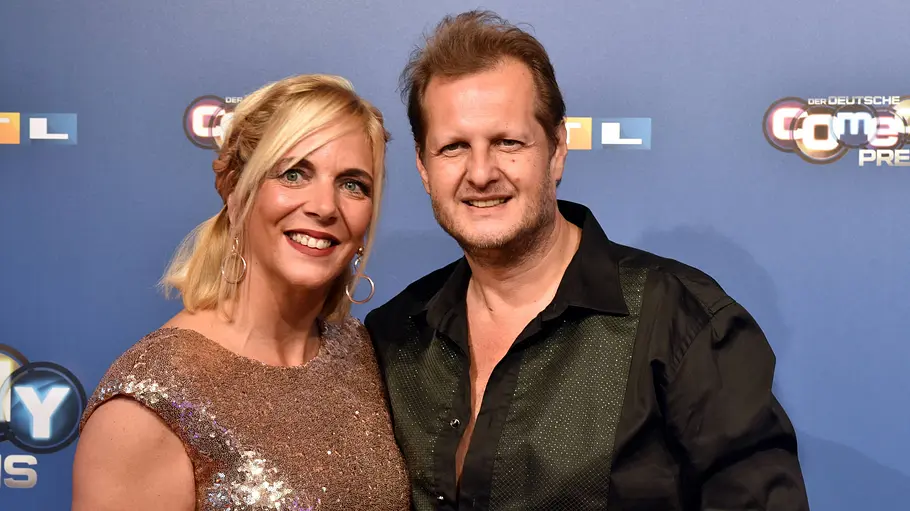 Danni und Jens Büchner stehen vor einer Fotowand des Deutschen Comedypreis.