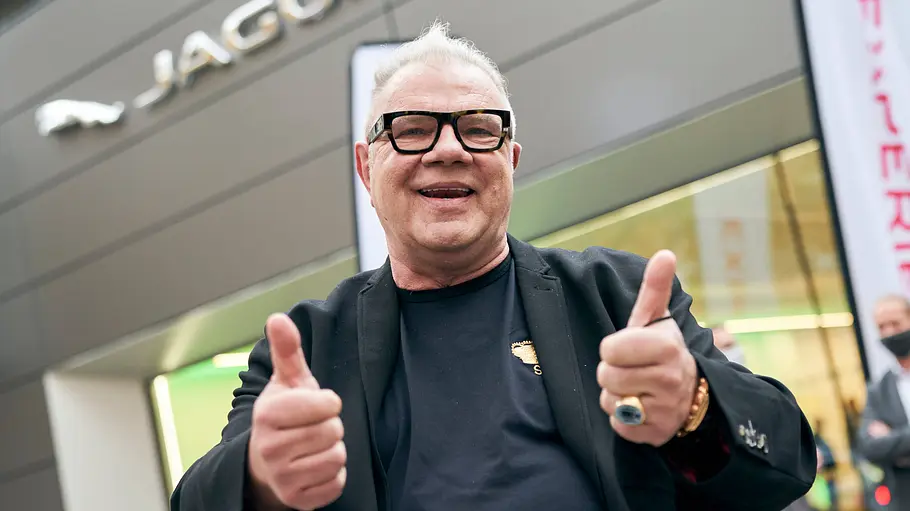 Fürst Heinz zeigt bei einer Autohaus-Neueröffnung mit zwei Daumen nach oben.