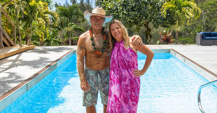 Konny und Manuela Reimann stehen in luftigen Klamotten vor einem Pool