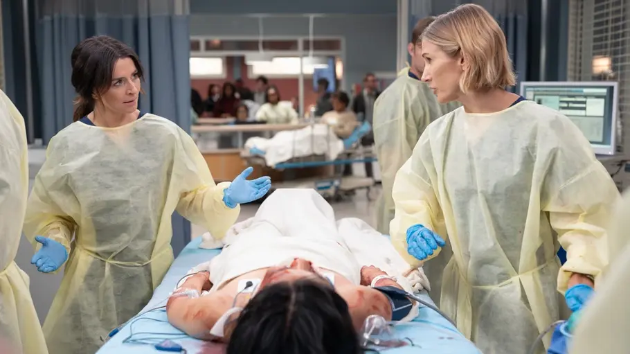 Greys Anatomy: Amelia und Toni kommen sich wieder näher Amelia und Toni stehen in Schutzkitteln und blauen Handschuhen neben einer verletzten Person auf einer Krankenhausliege.