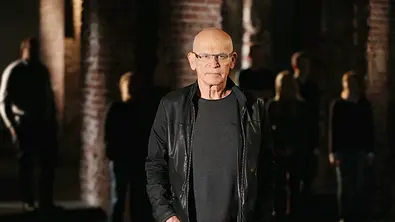 Günter Wallraff steht vor einer dunklen Wand und Menschen im Schatten - Foto: RTL / Stefan Gregorowius