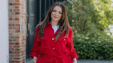 Anne Menden posiert im roten Outfit. - Foto: RTL / Anna Riedel