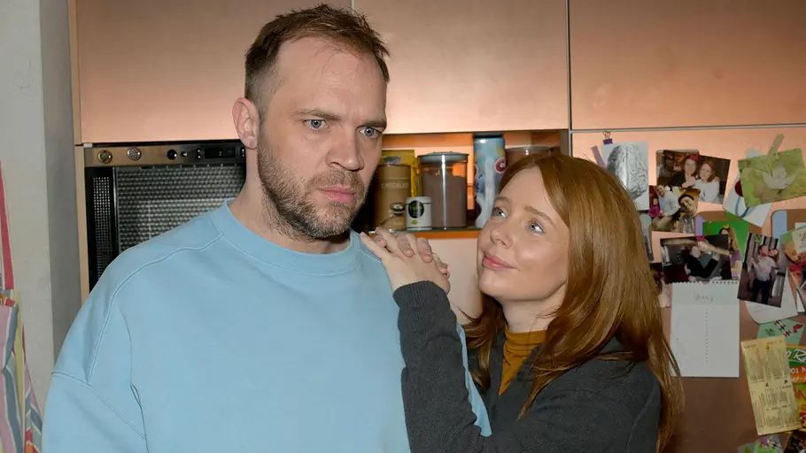 Erik ist gedankenverloren, während Toni zu ihm aufblickt.