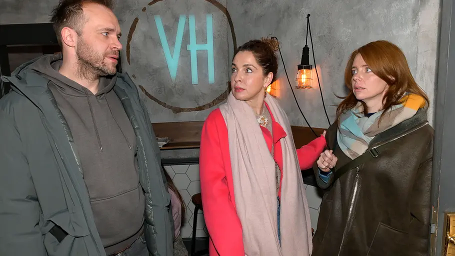 Nina stellt sich zwischen Erik und Toni. Nina und Toni schauen Erik sauer an.