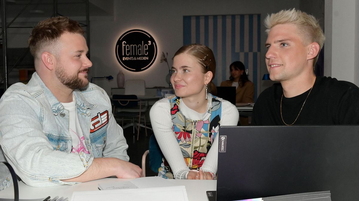 GZSZ-Szene: Johanna und Moritz sitzen zusammen mit Jonas am Schreibtisch. Die drei Freunde wollen Jonas' Musikkarriere retten.