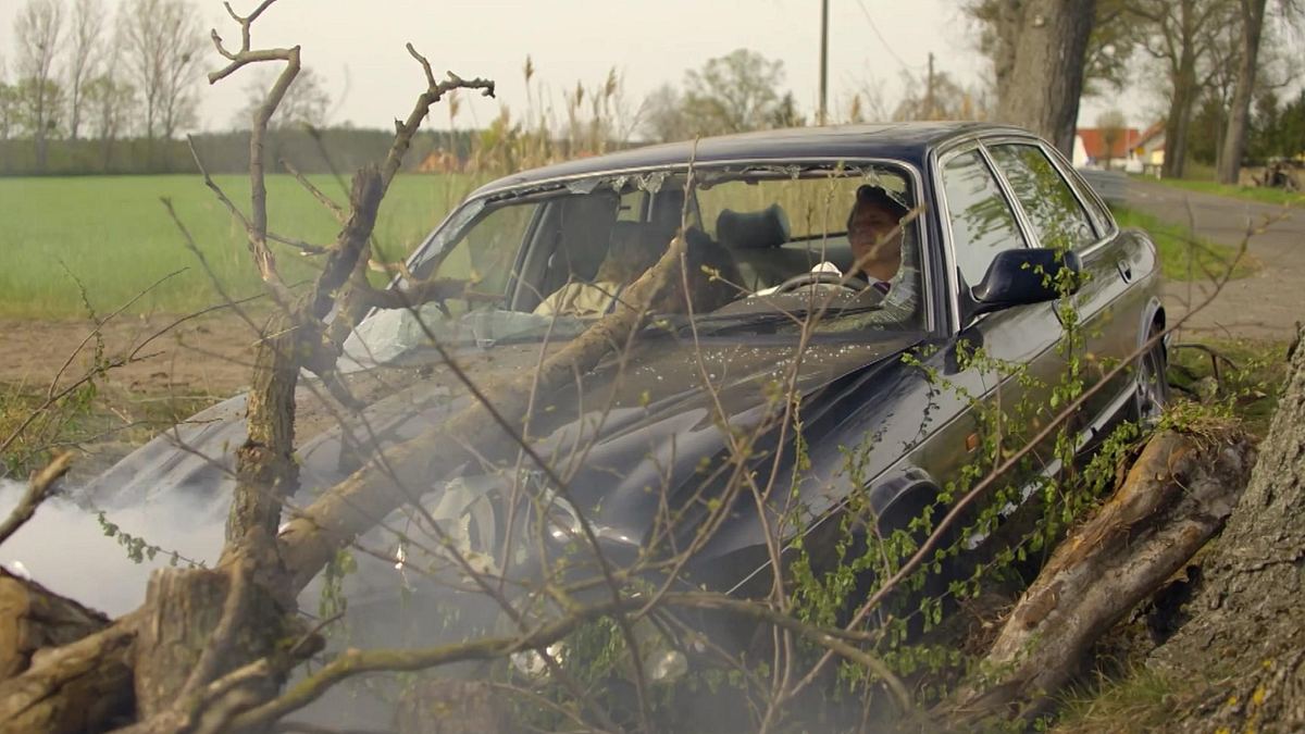 GZSZ-Szene: Gerner und Paulina sitzen im völlig demolierten Auto, nachdem sie gerade mit einem Baum kollidiert sind