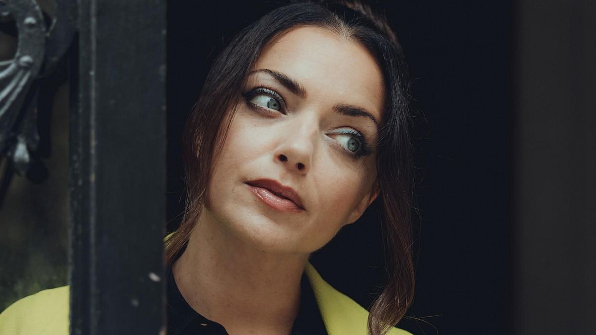 GZSZ-Star Anne Menden verkündet Planänderung GZSZ-Star Anne Menden schaut nachdenklich zur Seite und trägt einen gelben Blazer