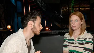GZSZ-Szene: Robin und Toni sitzen sich an einem Tisch gegenüber. Sie schaut ihn entsetzt an. - Foto: RTL / Rolf Baumgartner