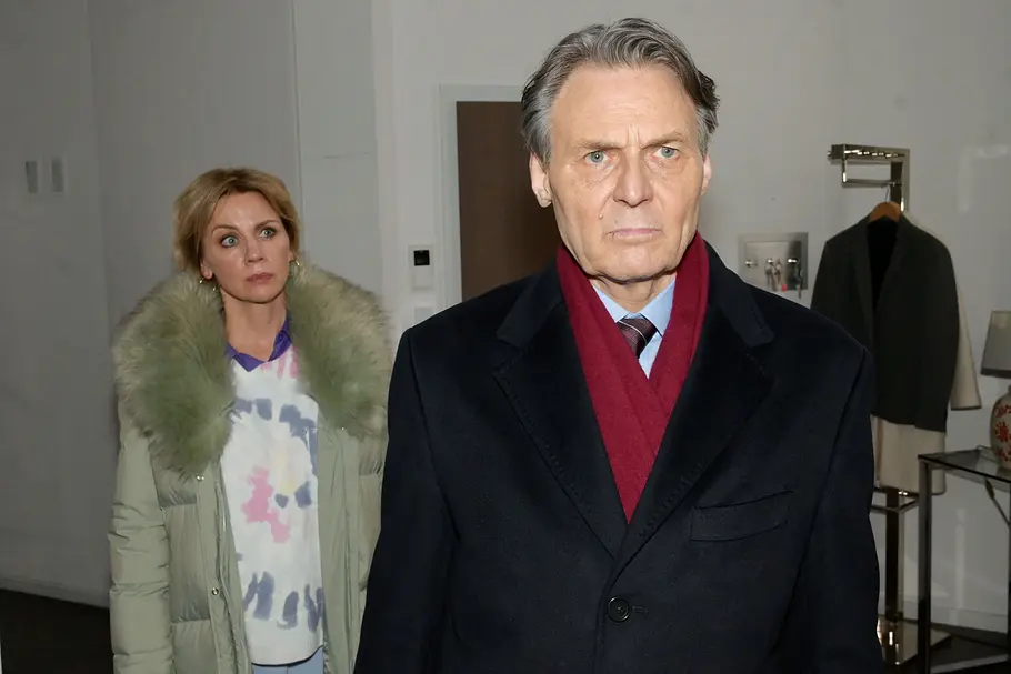 Yvonne schaut Gerner ernst an, während sie hinter ihm steht.