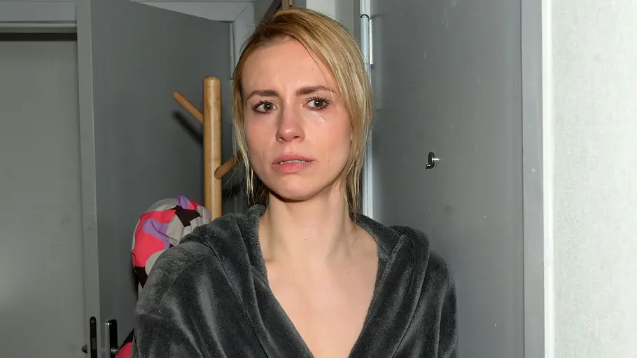Zoe wurde von Nina erschossen. Zoe schaut gedankenverloren mit Tränen in den Augen.