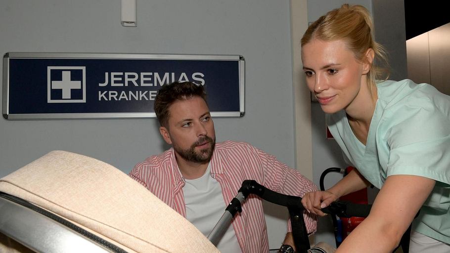GZSZ-Szene: John und Zoe sind mit Clara, die im Kinderwagen liegt, im Krankenhaus