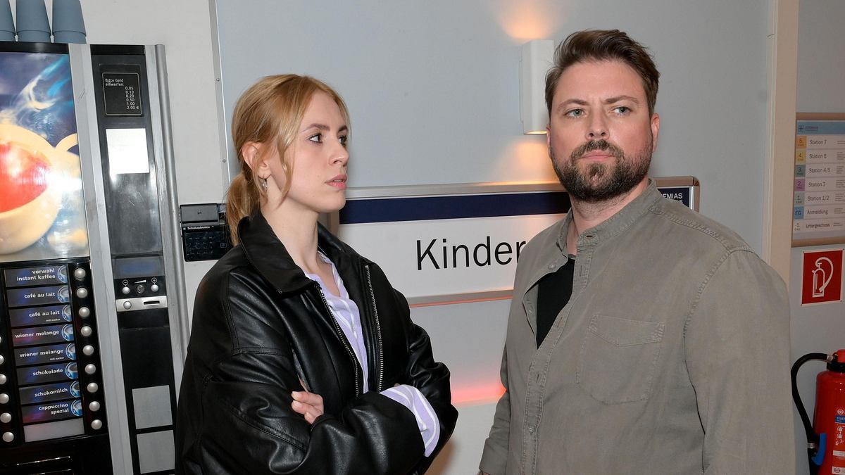 Zoe schaut John ernst mit verschränkten Armen an.