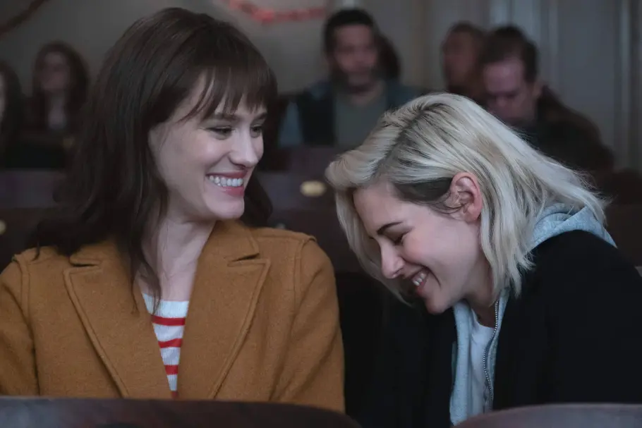 Happiest Season Mackenzie Davis als Harper und Kristen Stewart als Abby lachen beide.