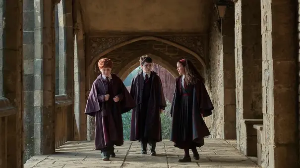 Ron Weasley (l.), Harry Potter (m.) und Hermine Granger (r.) laufen durch die Korridore Hogwarts. - Foto: Courtesy of HBO