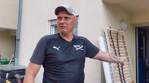 „Hartz und herzlich“-Elvis zeigt auf das kaputte Bett hinter ihm - Foto: RTLZWEI