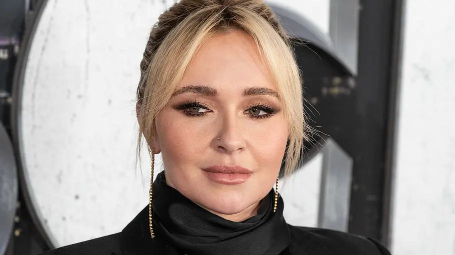 Hayden Panettiere Tod Ermittlungen Hayden Panettiere trägt einen schwarzen Blazer und Schal, lange goldene Ohrringe und ihre blonden Haare zum Dutt gebunden.