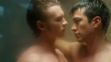 Ilya und Shane stehen sich nackt und eng in einer dampfenden Dusche gegenüber. Sie schauen sich intensiv in die Augen, der Moment wirkt sehr intim und emotional. Das Licht ist weich und die Scheibe leicht beschlagen. - Foto: Sabrina Lantos/HBO Max