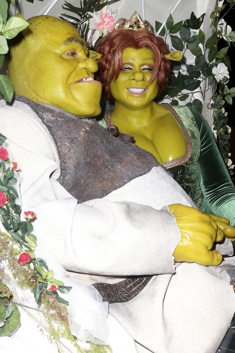 Heidi Klum und Tom Kaulitz zu Halloween 2018 Shrek Tom Kaulitz als Shrek und Heidi Klum als Fiona sitzen an Halloween 2018 mit grüner Schminke zwischen Blumen und Blättern und halten sich an den Händen.