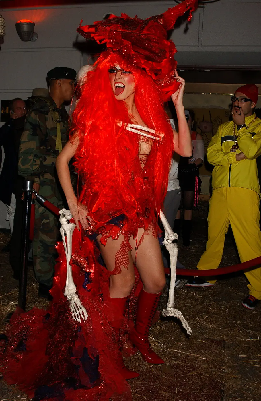 Heidi Klum zu Halloween 2004 als rote Vampier-Hexe Heidi Klum trug zu Halloween 2004 ein rotes Kostüm mit langer roter Perücke, großem drachenförmigem Kopfschmuck und herabhängenden Skelettarmen.