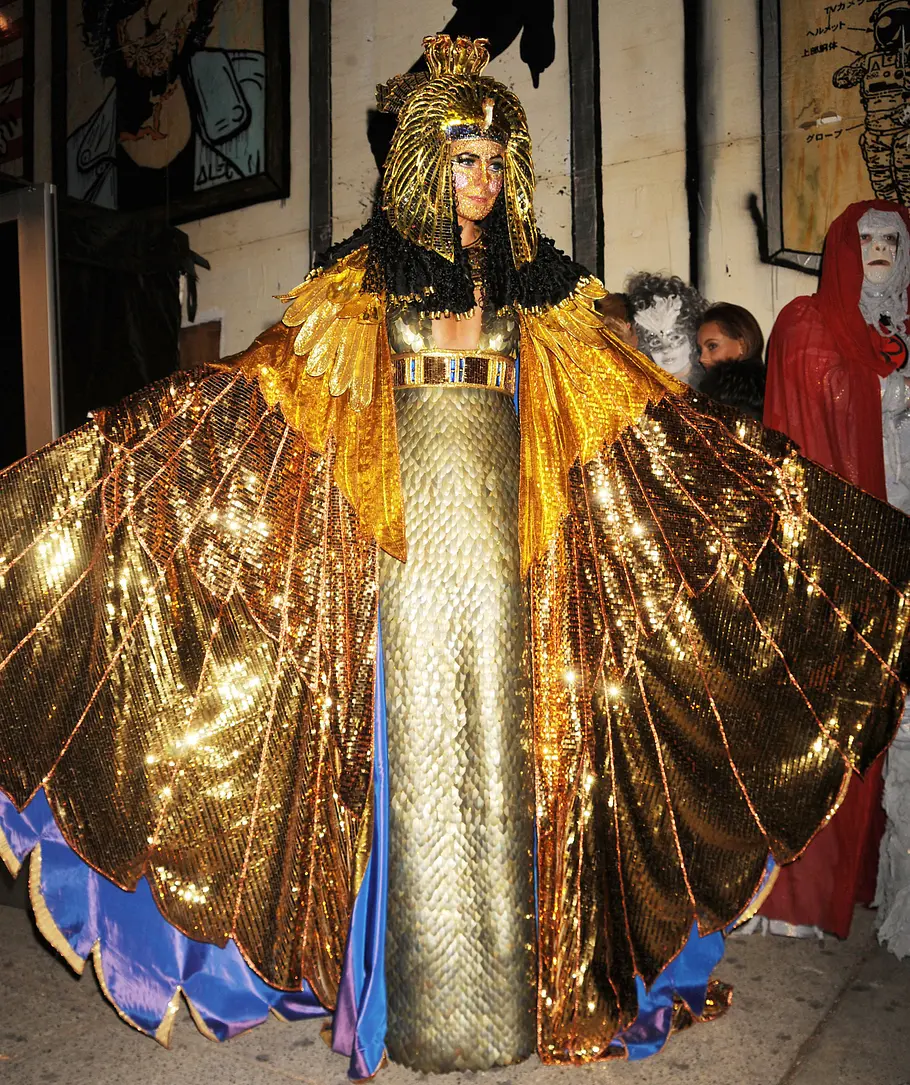 Heidi Klum zu Halloween 2012 als Kleopatra Heidi Klum trug zu Halloween 2012 ein goldenes Kostüm mit bodenlangem Schuppenkleid, ausgebreiteten Flügeln und ägyptisch anmutendem Kopfschmuck.