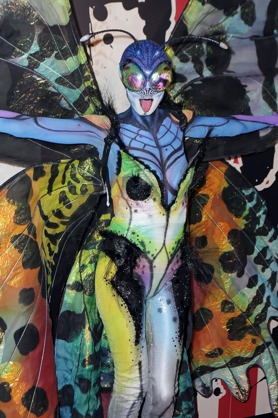 Heidi Klum zu Halloween 2014 als Schmetterling Heidi Klum posiert an Halloween 2014 mit ausgebreiteten Armen in einem bunten Schmetterlingskostüm mit riesigen Flügeln und einer Insektenmaske.