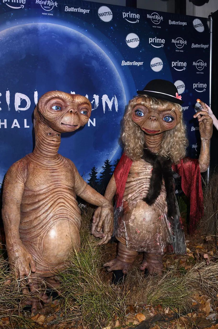 Heidi Klum zu Halloween 2024 E.T. Tom Kaulitz (links) und Heidi Klum (rechts) an Halloween 2024 in E.T.-Kostümen vor einer Logowand.