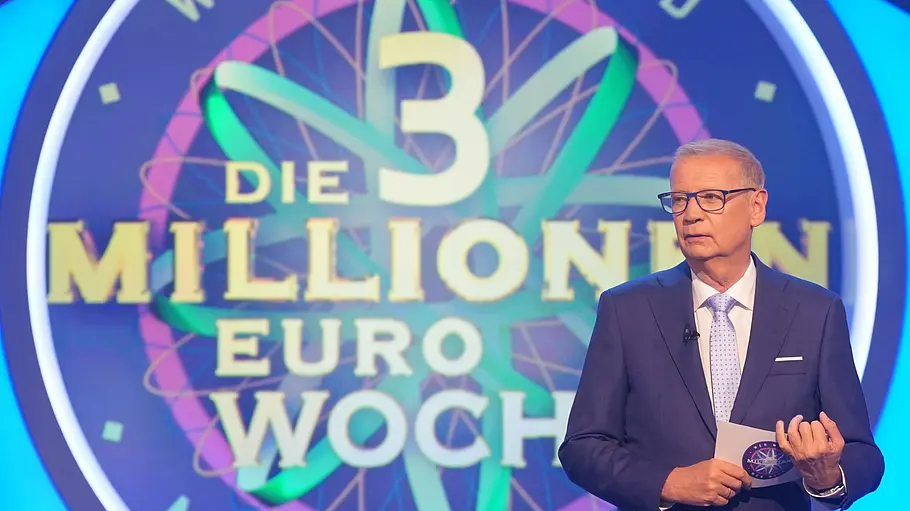 Günther Jauch: Heute steigt das Finale der „Wer wird Millionär?“-3-Millionen-Euro-Woche Günther Jauch steht mit Brille, Anzug und Moderationskarte vor dem bunten Schriftzug „Die 3 Millionen Euro Woche“.