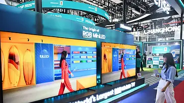 2025 läuft eine Frau auf einer technik Messe in China an den RG Mini LED Fernsehern von Hisense vorbei. - Foto: IMAGO / Xinhua