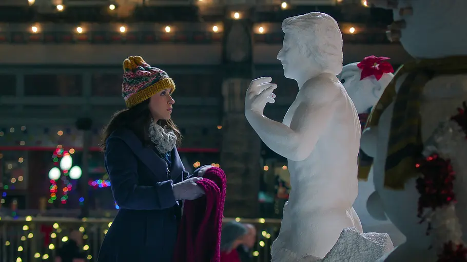 Bild zeigt Frau mit Schal in der Hand stehend vor einem Schneemann